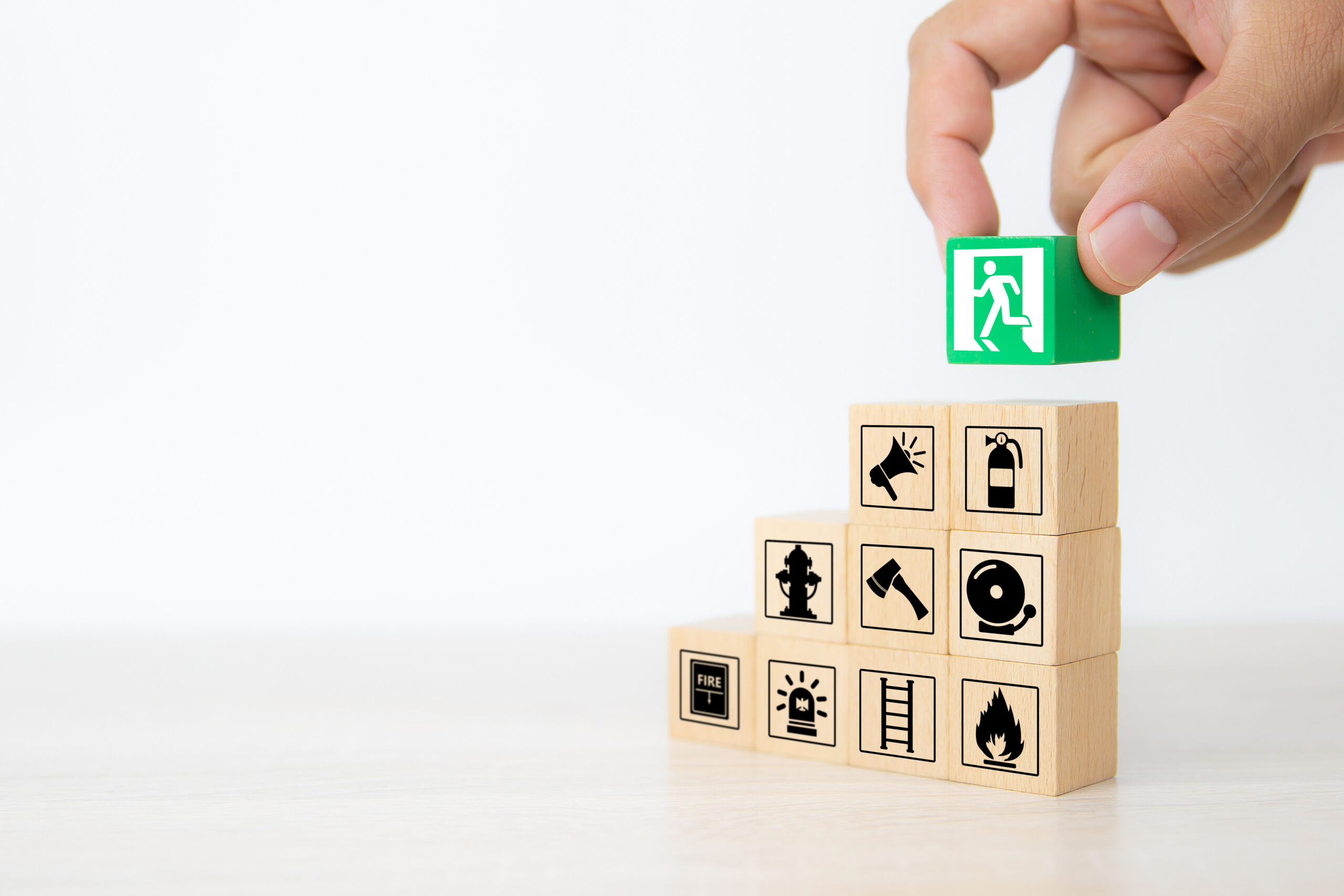 Close-up hand choose wooden blocks stacked with door exit icon